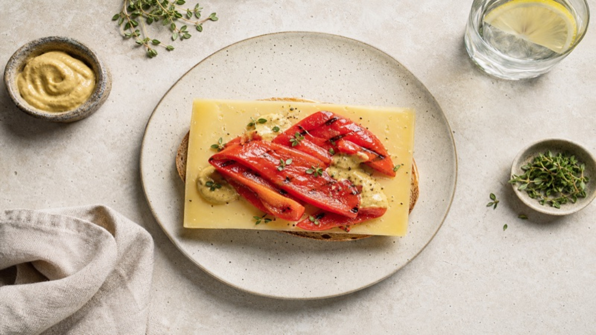 Bergkäse-Scheibe mit gegrillter roter Paprika und Senf