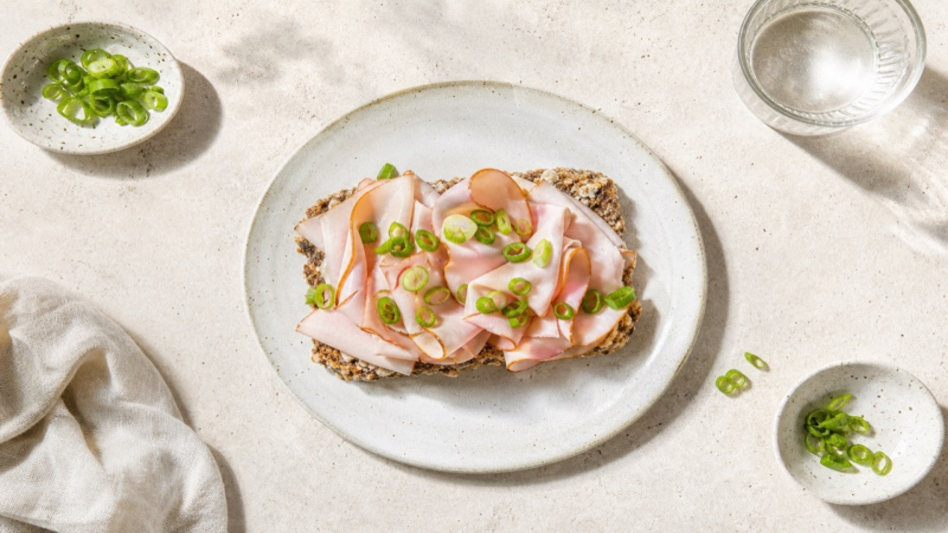 Geräucherter Putenschinken auf Dinkelknusperbrot mit Frühlingszwiebeln