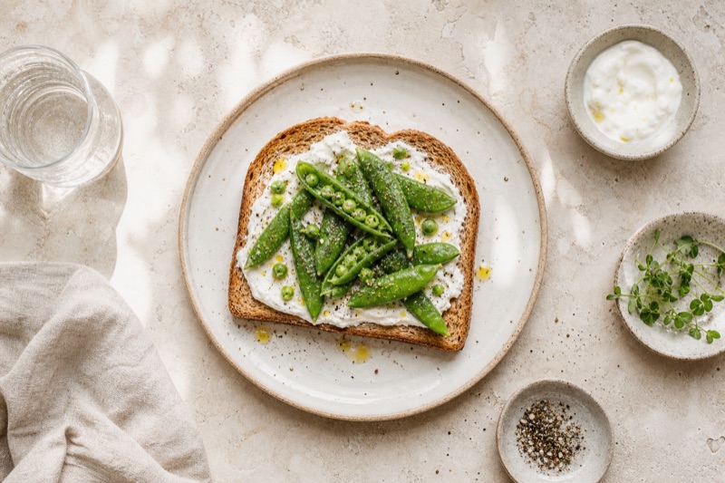 Goldbrauner Vollkorntoast mit Joghurt und Zuckererbsen