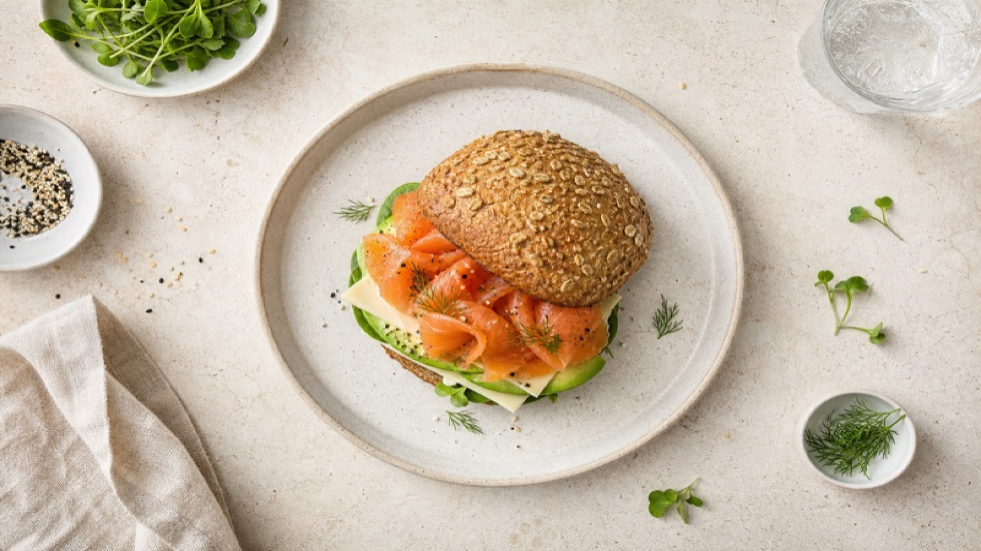 Goldbraunes Weizenvollkornbrötchen mit Räucherlachs und Avocado-Schichtkäse