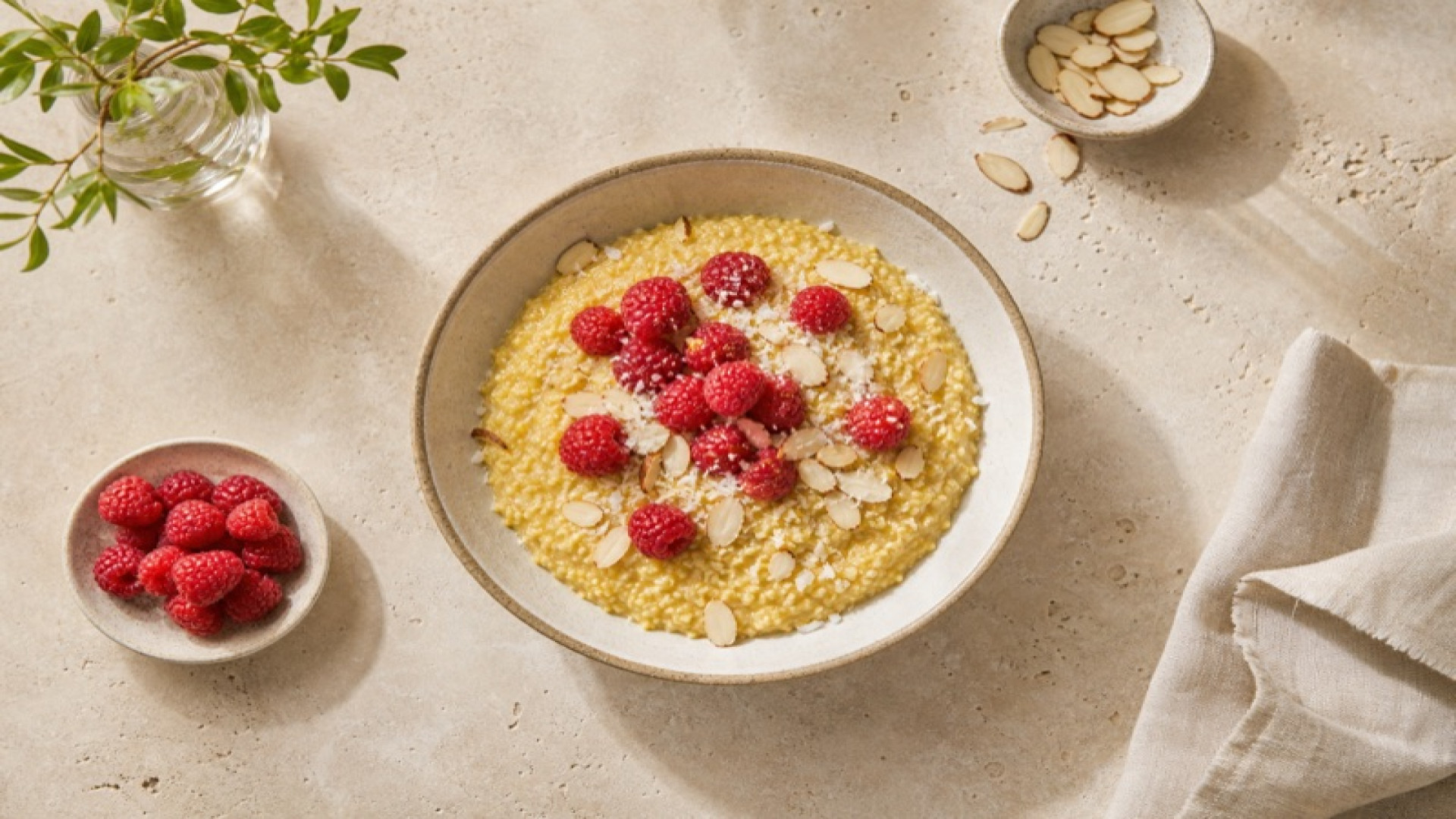 Goldenes Hirse-Porridge mit Himbeeren und Mandeln