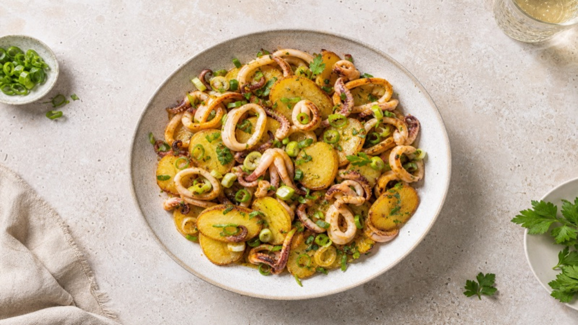 Goldgelbe Kartoffel-Tintenfisch-Pfanne mit Frühlingszwiebeln