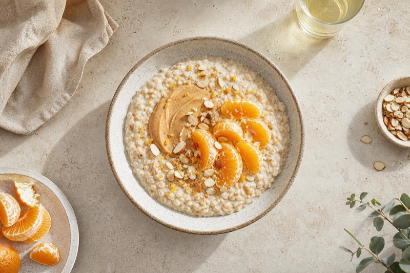 Hafer-Schrot-Porridge mit Mandelmus und Mandarinen