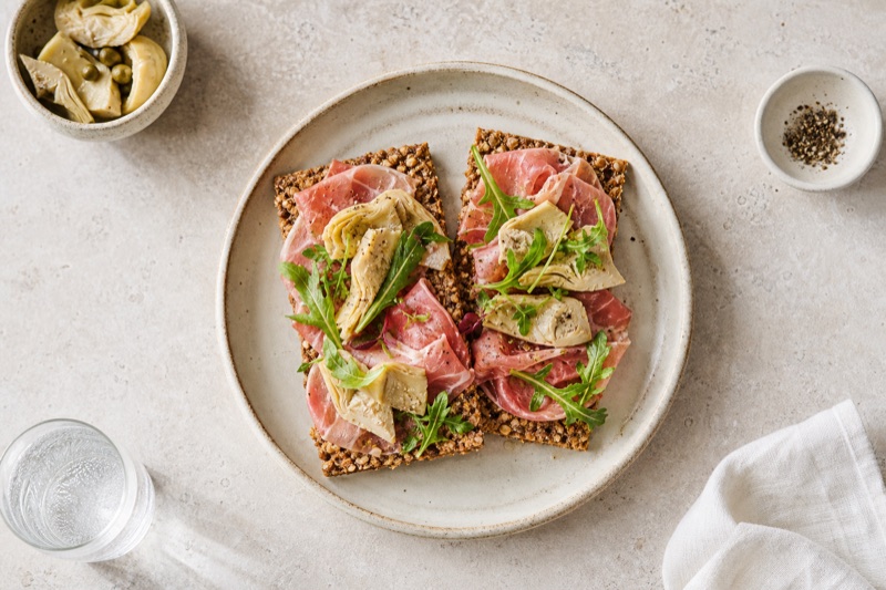 Herzhaftes Roggenvollkorn-Knäckebrot mit Geräuchertem Schinken und Artischocke