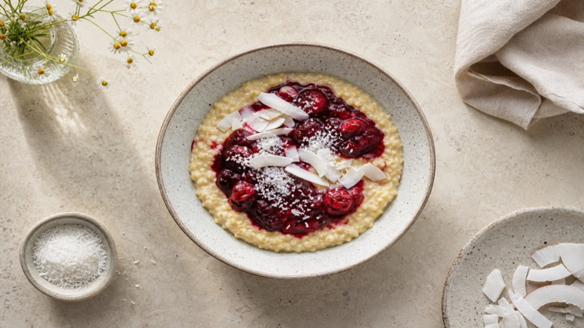Hirse-Porridge-Bowl mit roter Grütze und Kokos