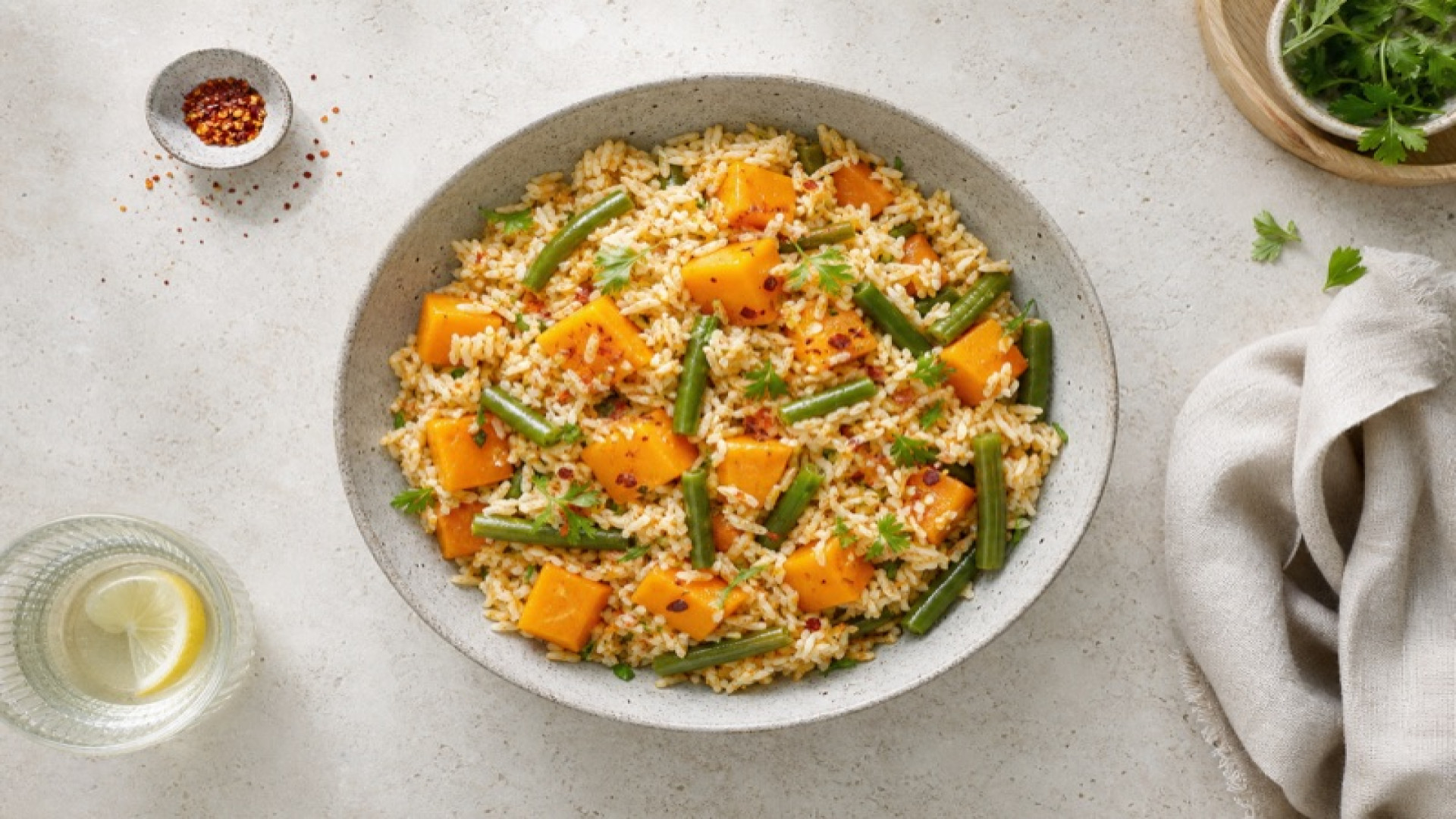 Kürbis-Reismischung mit grünen Bohnen und Chiliflocken