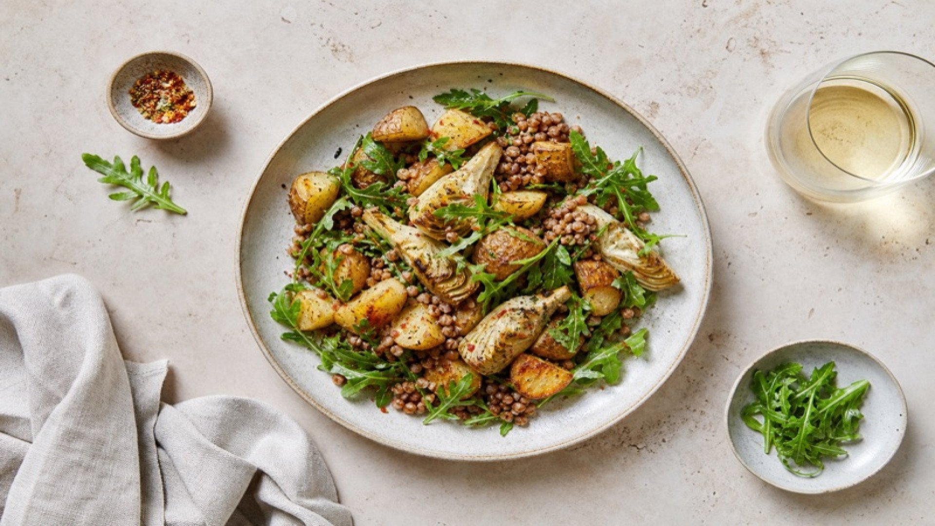 Pikanter Kartoffel-Buchweizen-Teller mit Artischocken und Rucola