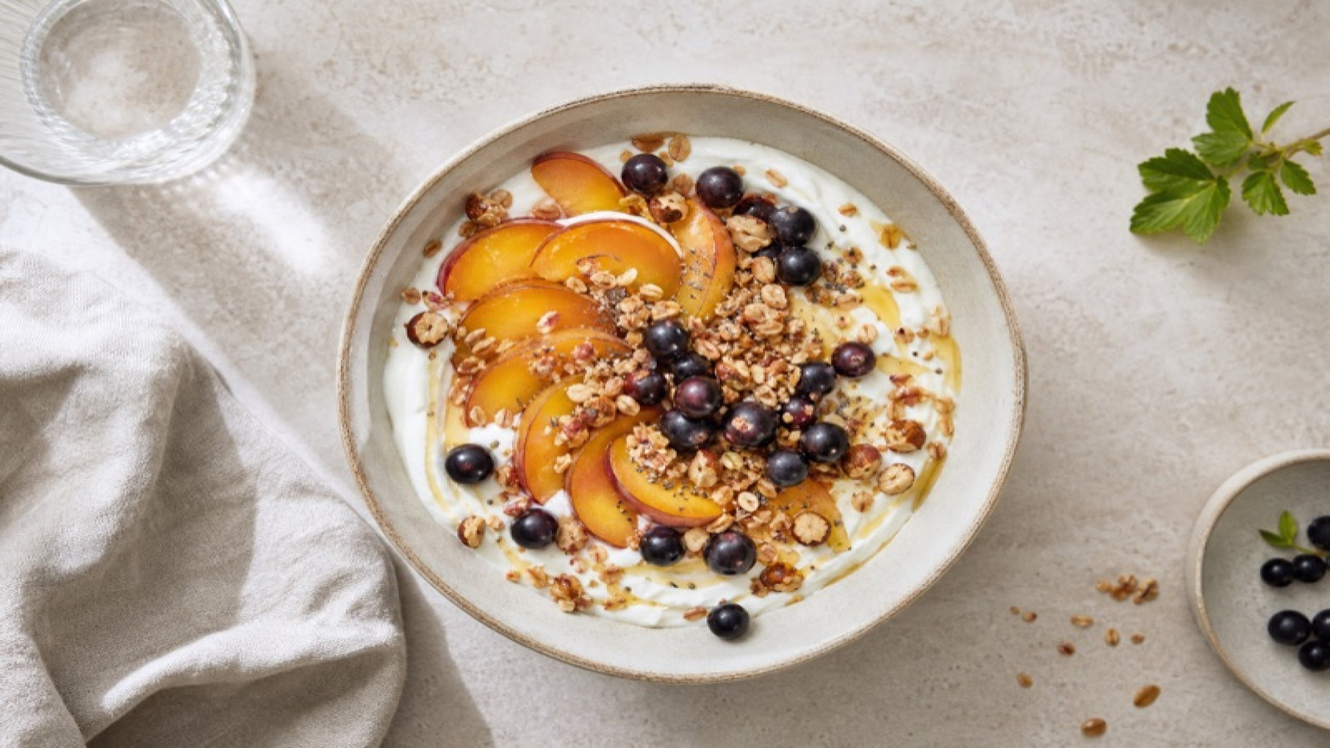 Reineclauden-Joghurt-Bowl mit Granola und schwarzen Johannisbeeren