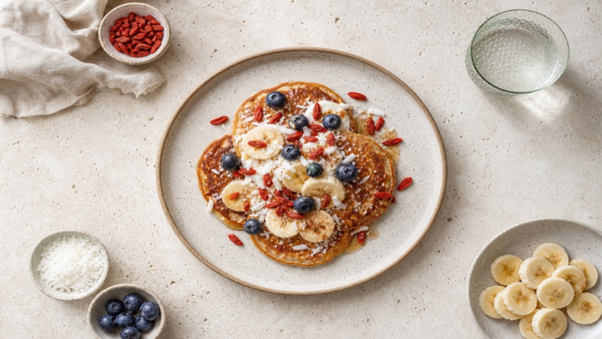 Vegane Pancakes mit Goji Beeren, Banane und Kokosnussflocken
